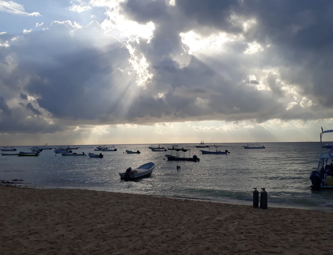 Tauchsafari-Boote auf dem Meer im Morgengrauen, Wolken und Sonnenstrahlen durchziehen den Himmel